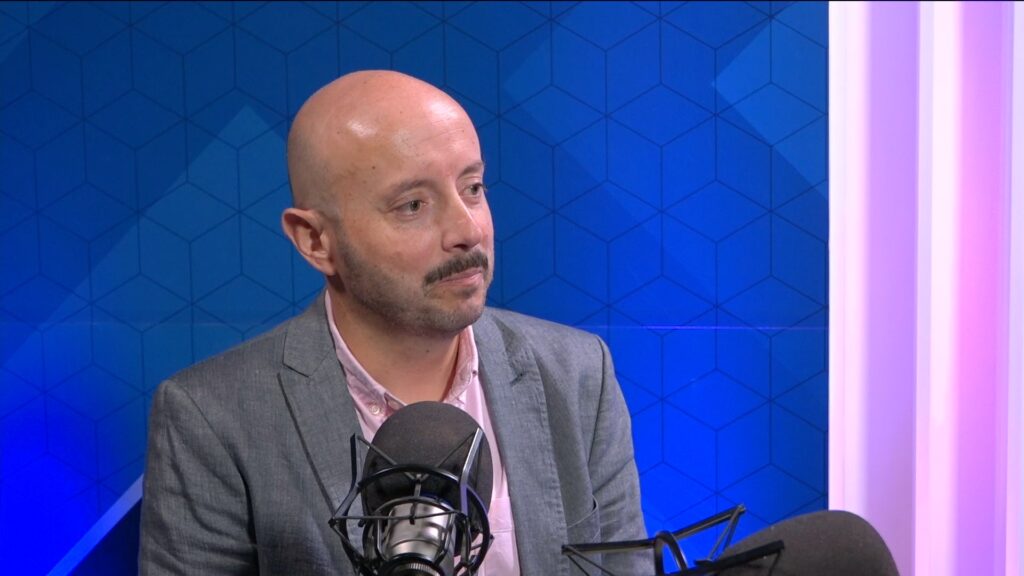 El académico Rodrigo Palomo conversando frente a un micrófono en el estudio del programa Código Claro de UTalcaTV.